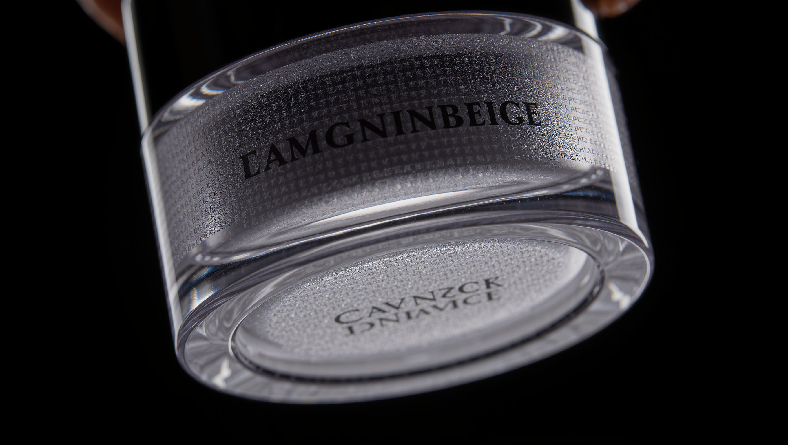 Ein umgedrehter Glastiegel mit eng bedrucktem Etikett steht im Gegenlicht, die Schrift ist unscharf und unlesbar